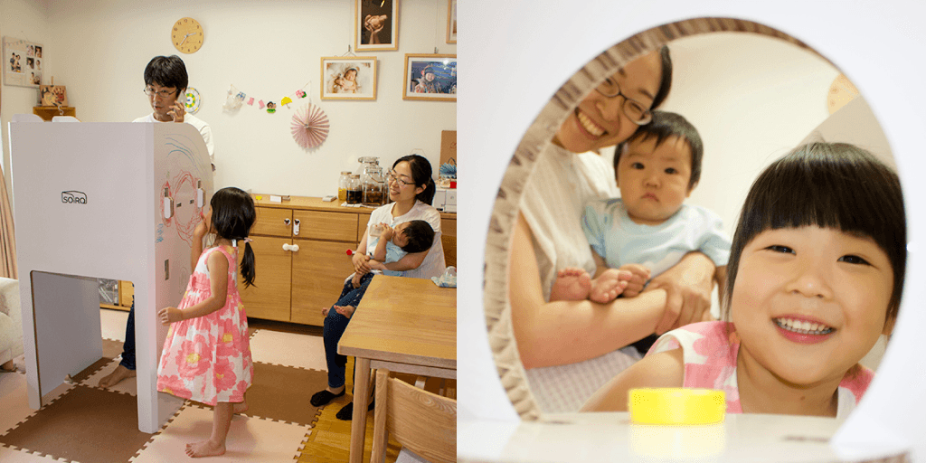 親子がSOiROの丸窓越しに向き合う様子